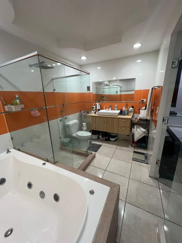Contemporary bathroom with jacuzzi, glass shower, orange tiles in Panama house in Brisas del Golf