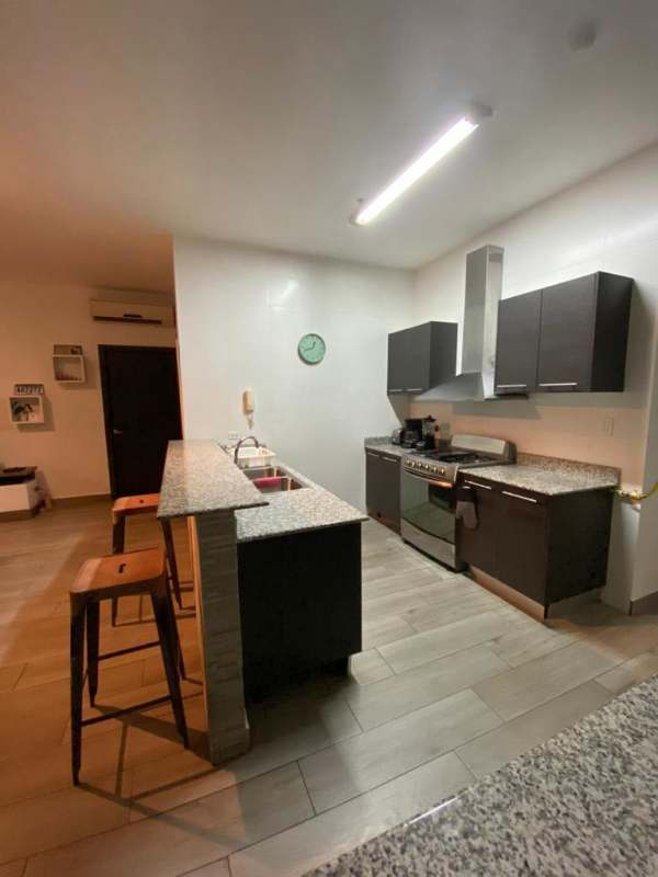 Elegant lobby with white sofas, glossy black tile floor and red accents PH Quadrat Panama