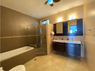 Spacious bathroom with glass shower and double sink vanity in PH Soleo apartment Panama Pacifico