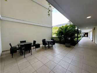Dining room with wooden table, pendant light and balcony access in furnished PH Soleo apartment Panama Pacifico