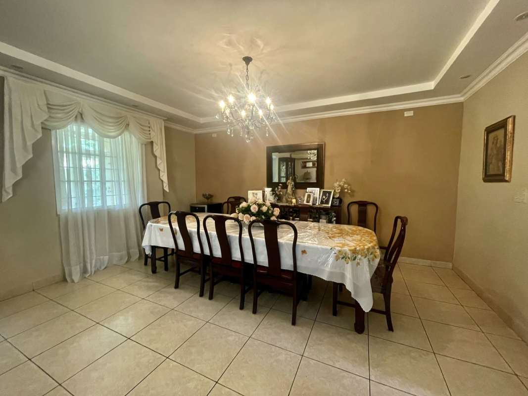 Traditional dining area with large window, chandelier and tile floor in Costa Dorada Costa del Este Panama