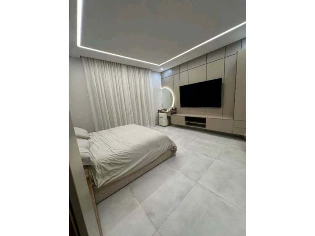 Master bedroom with accent lighting, panel walls, sofa and neutral tones Panama luxury house for rent