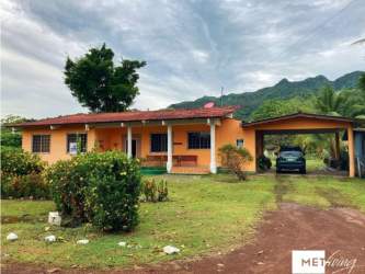 Bright living room with bookshelves, ceiling fan, and decorative accents in countryside house near Coronado Panama