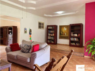 Dining space with glass table, blue door, wooden cabinets in country house near Coronado