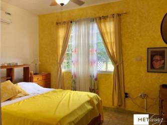 Bedroom with colorful walls, air conditioning, and window in countryside house near beaches Panama