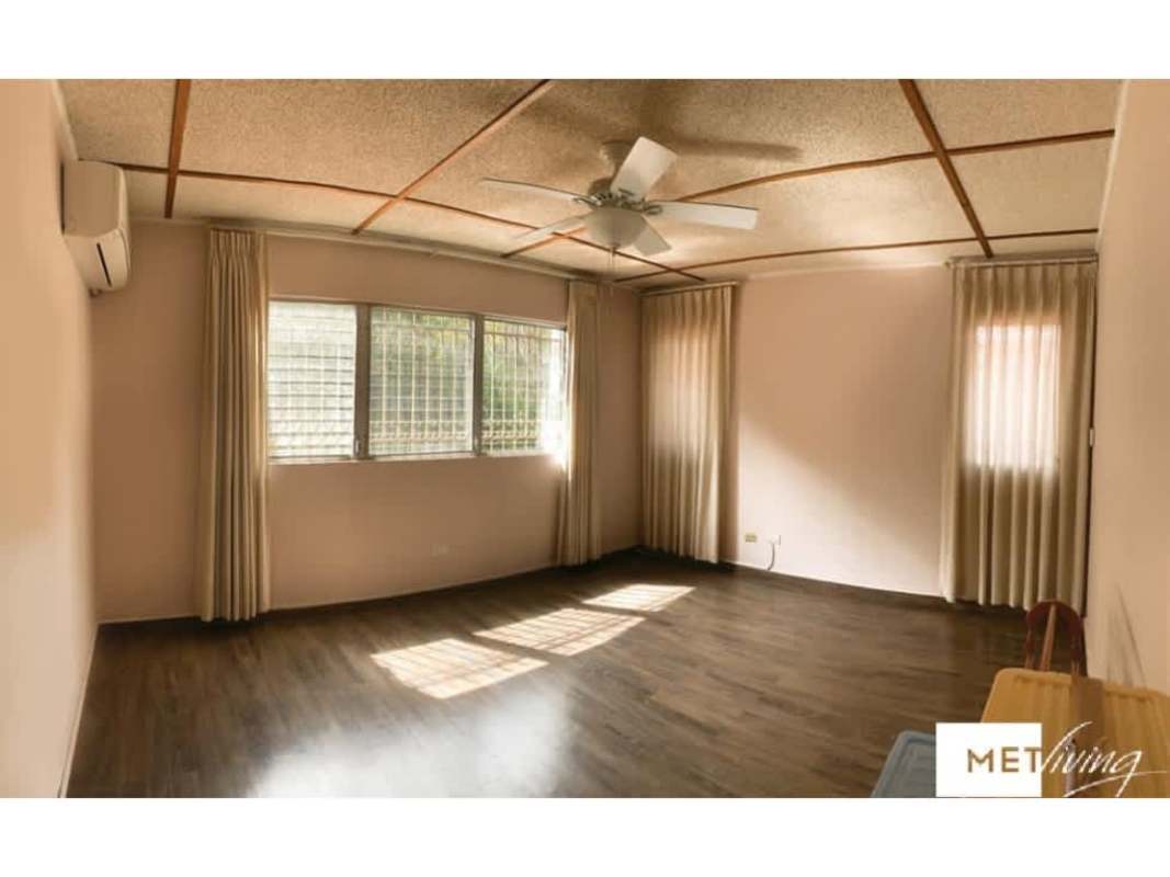 Bright minimalist living room with windows, curtains, wood-style floor, air conditioning, in La Alameda Panama