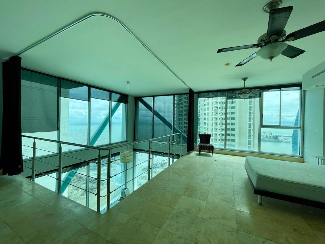 Modern loft bedroom with ceiling fans, tile floor, big windows showing ocean at PH Loft Four41 Panama