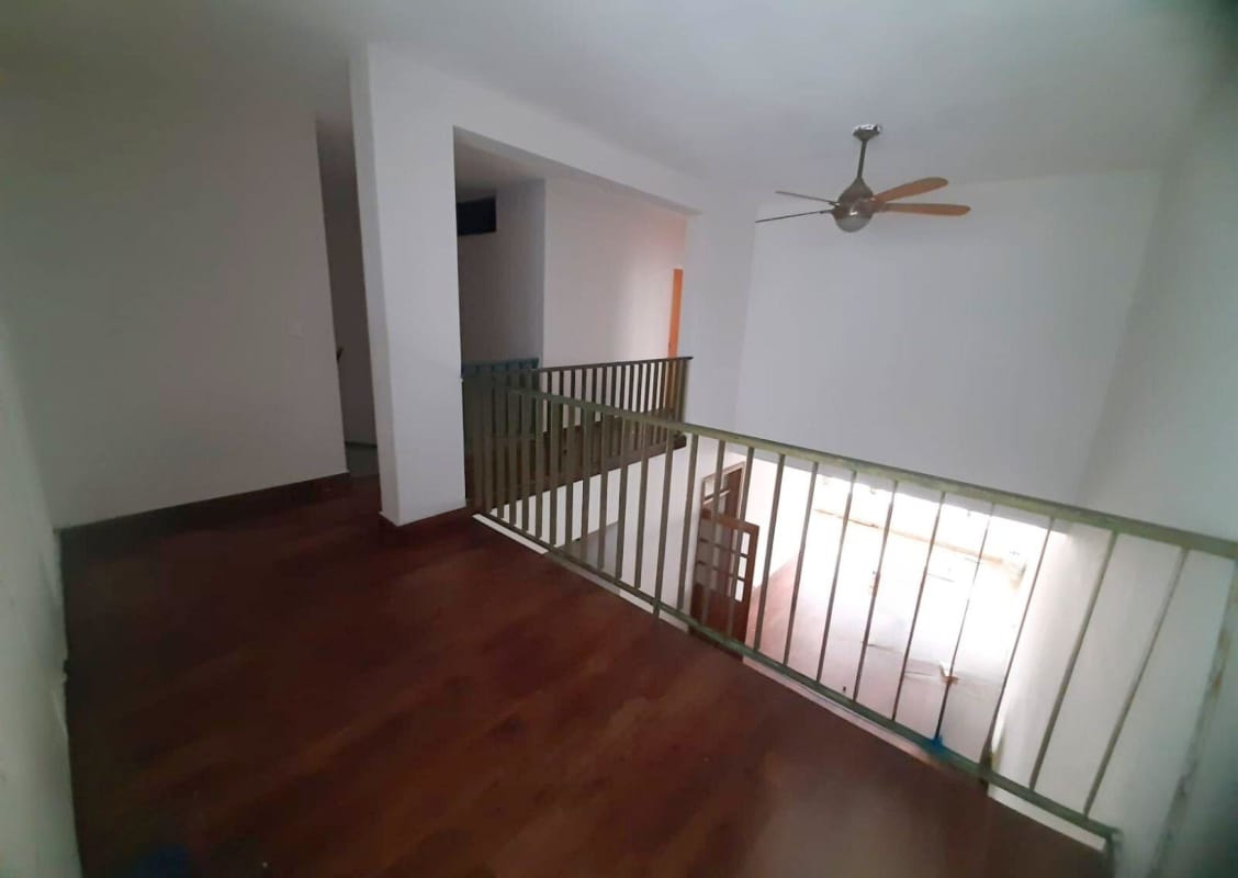 Upper level mezzanine with railing, wooden floors, open versatile den area overlooking living room