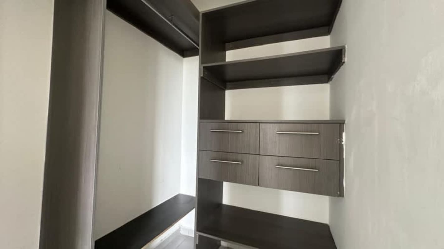 Minimalist bedroom with built-in dark wardrobe in repossessed apartment Condado del Rey Panama