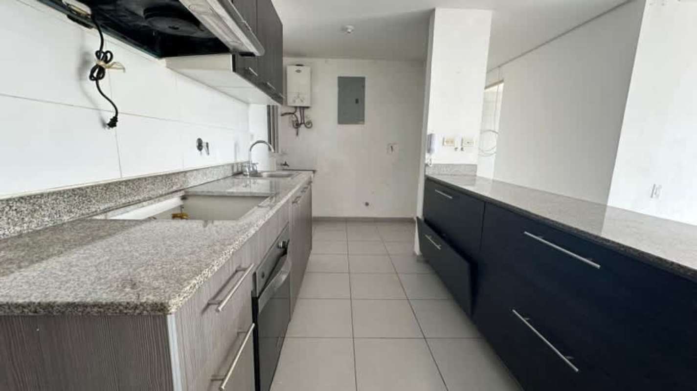 Modern minimalist kitchen with granite counters and gray cabinets in Condado del Rey apartment sale Panama