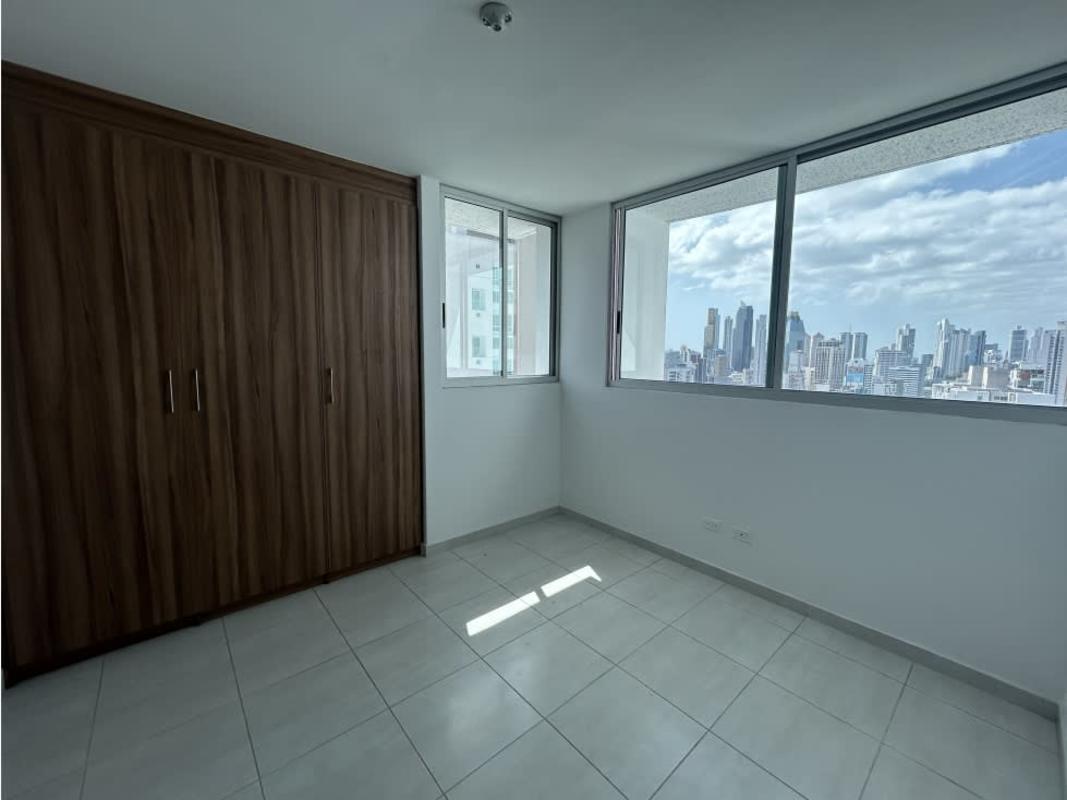 Modern empty bedroom in Trinity Tower featuring large windows and city panoramic views