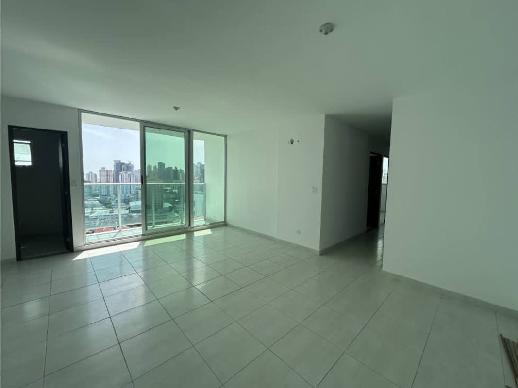 Bright living space with large sliding doors opening to balcony city skyline Trinity Tower