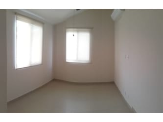 Bedroom with built-in wood wardrobes, split AC unit, balcony with views of green areas in River Valley Panama Pacifico