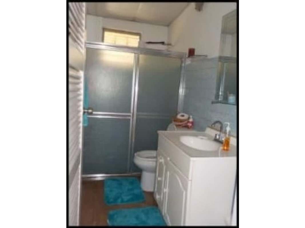 Traditional bathroom with frosted shower glass door, vanity and turquoise rugs Las Cumbres