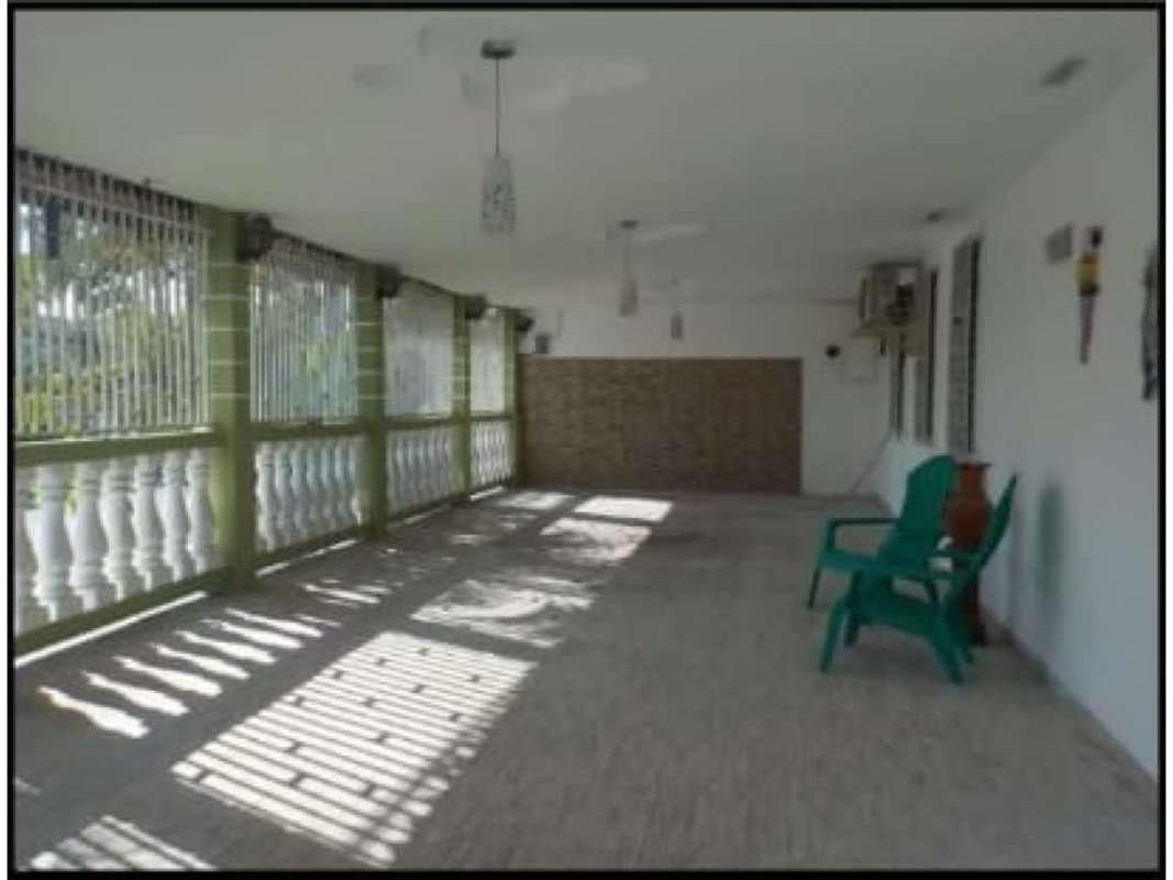 Covered porch terrace with decorative railings, lights and green chairs Las Cumbres Panama
