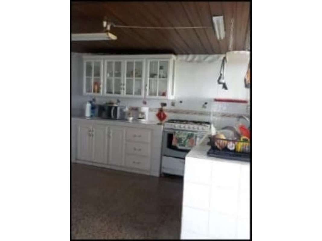 Spacious kitchen with white cabinets, wooden ceiling, gas stove in Las Cumbres Panama