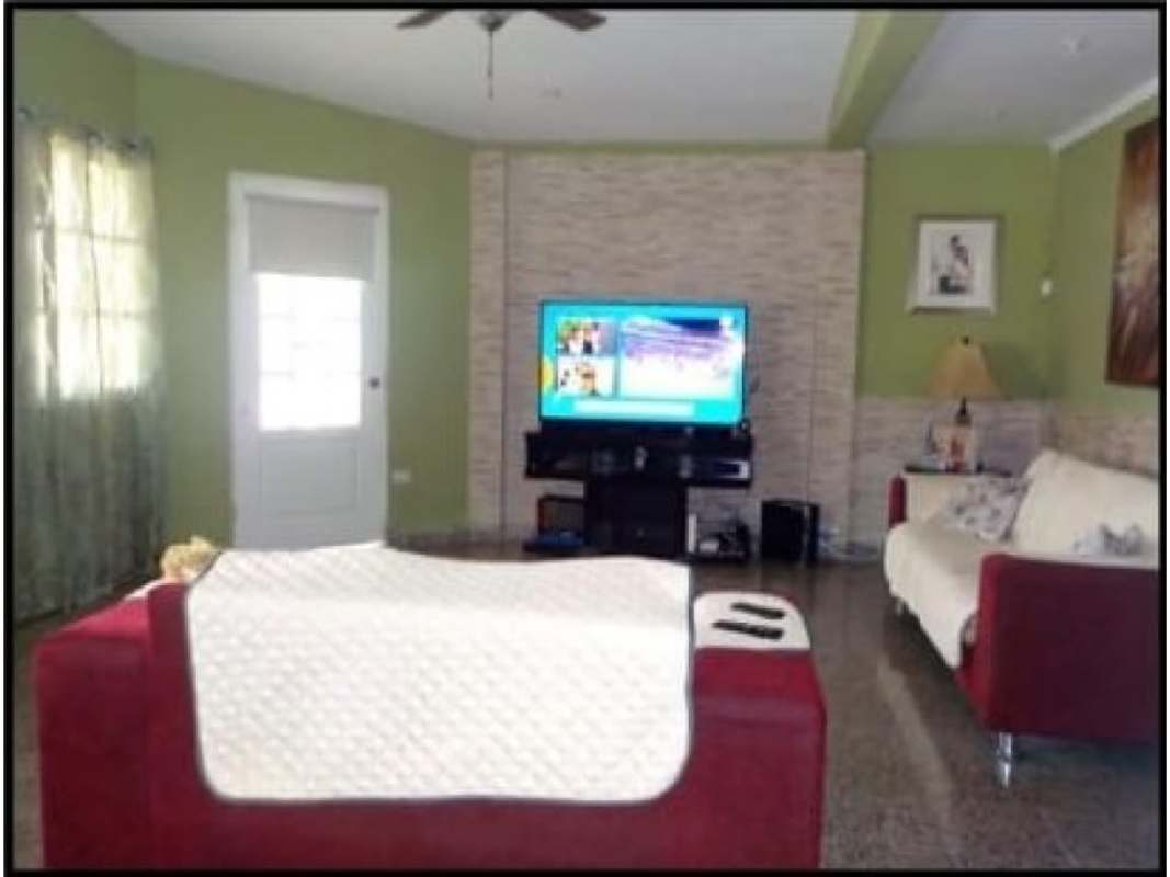 Living room with TV, stone accent wall, sofas and ceiling fan in Las Cumbres Panama