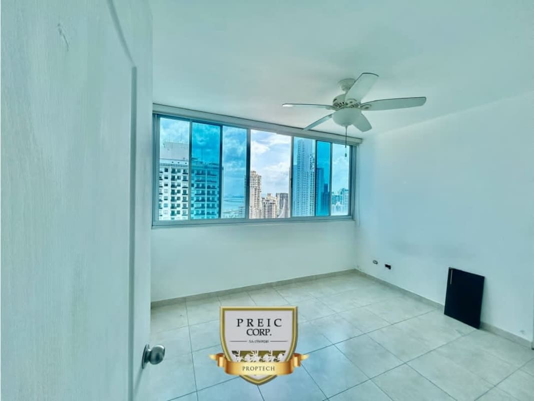 Bright bedroom with ceiling fan and panoramic window at PH Seawaves Panama