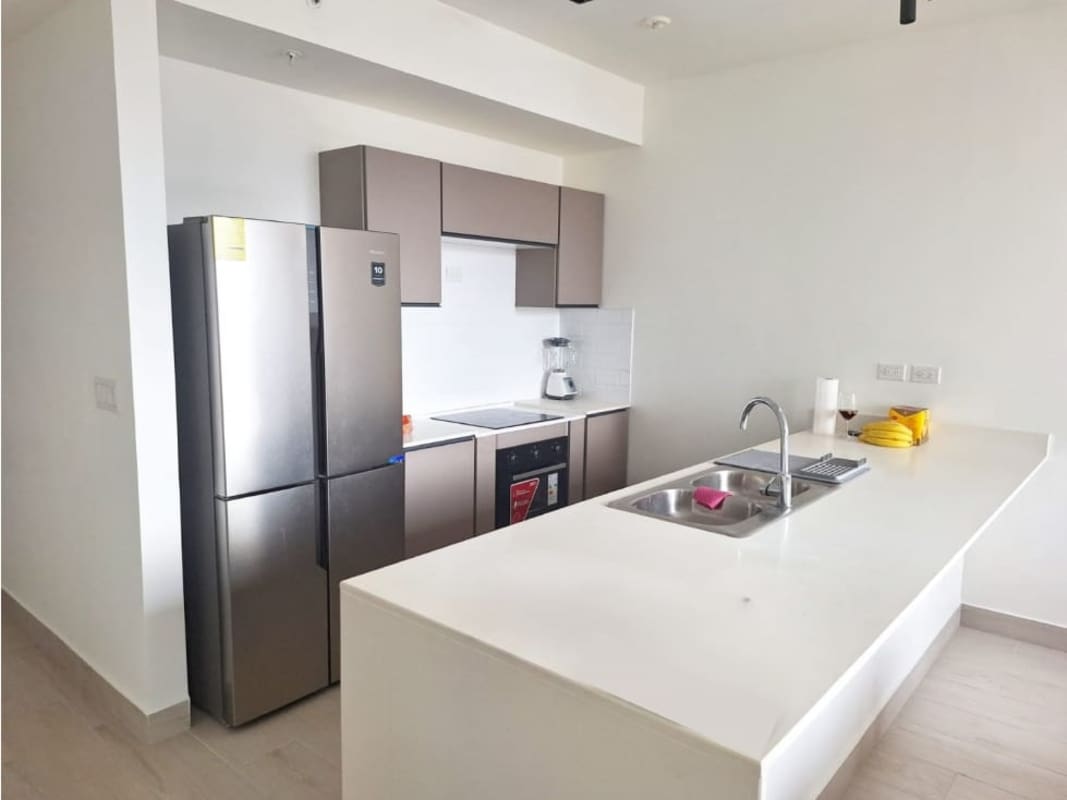 Stainless steel appliances and island in open kitchen design at PH Urbana in Obarrio Panama City
