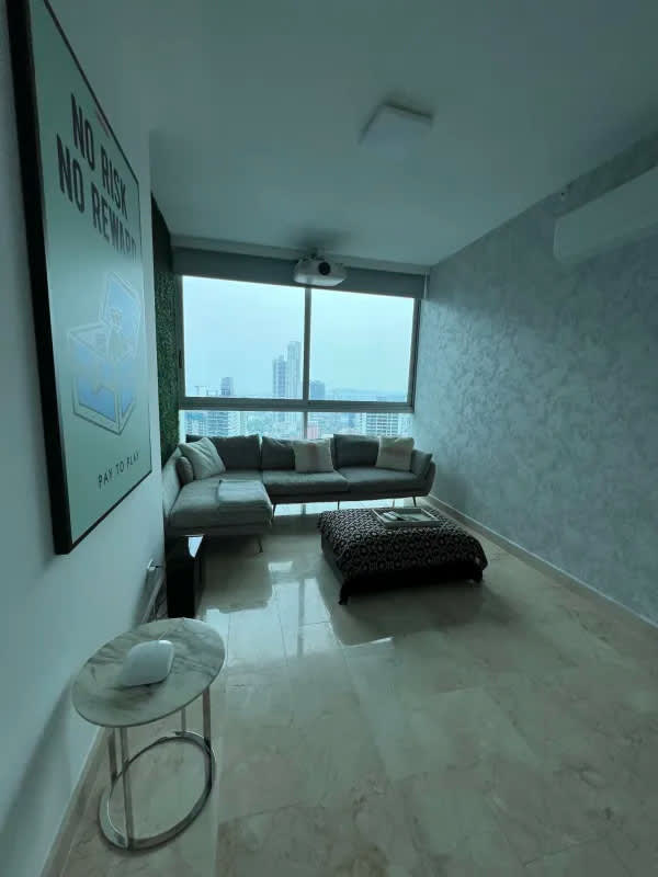 Open living room with marble floors, city skyline, and ocean views in PH Dynasty Residences Panama