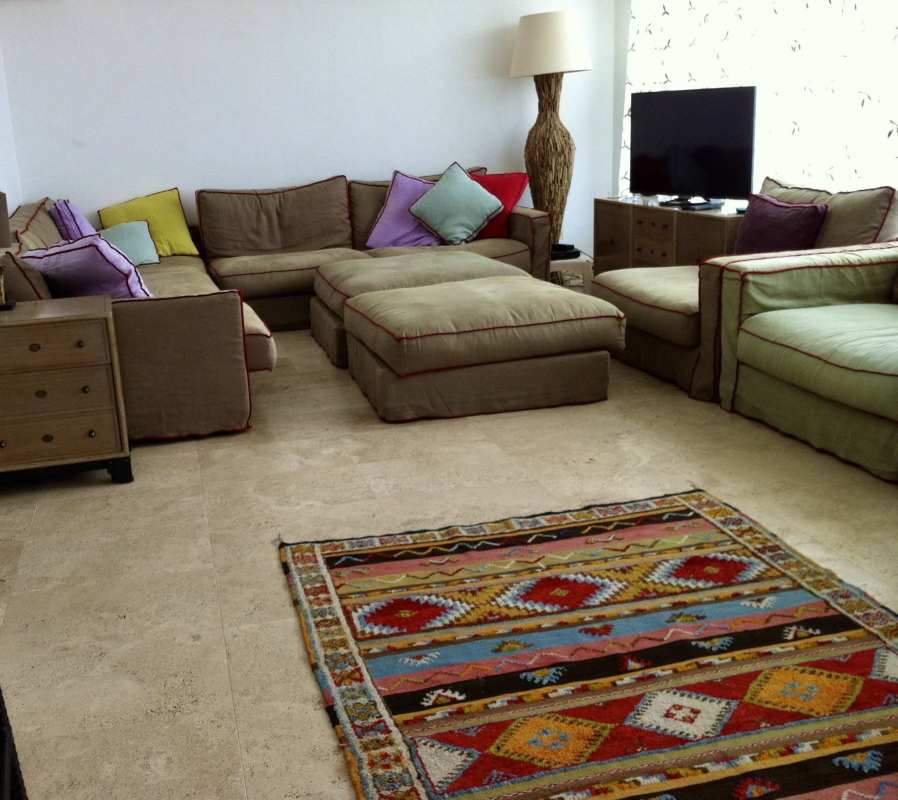 Furnished living area with large sectional sofa, colorful decor, and flat screen TV in PH El Cangrejo Junior Penthouse Panama City