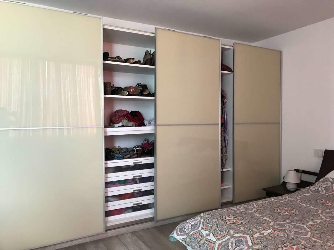 Built-in closet space with sliding doors and modern storage in bedroom El Cangrejo penthouse