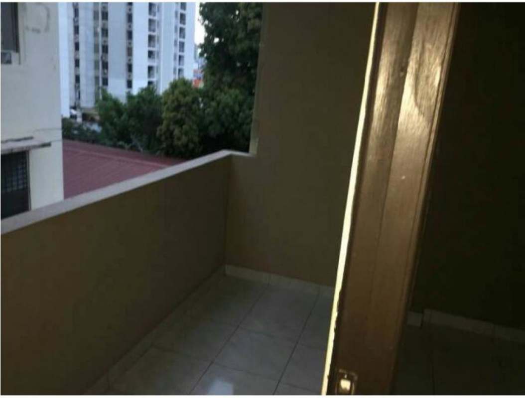 Small balcony with tiled floor overlooking city buildings and greenery PH Veracruz Carrasquilla