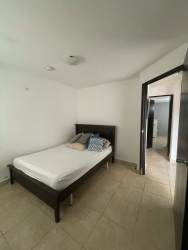Bedroom tiled floor neutral colors simple furnishings door to other room rental Panama