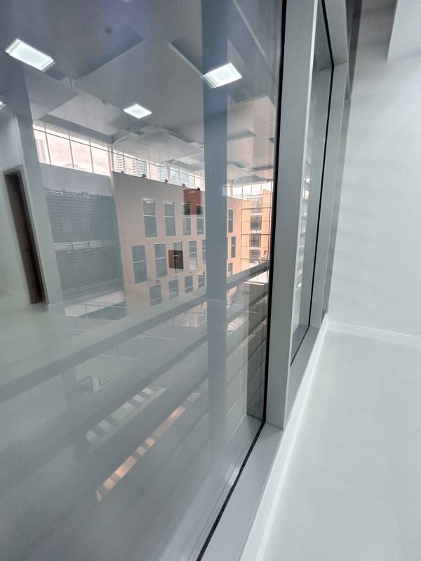 Hallway with floor-to-ceiling glazing and cityscape reflections Town Center Panama