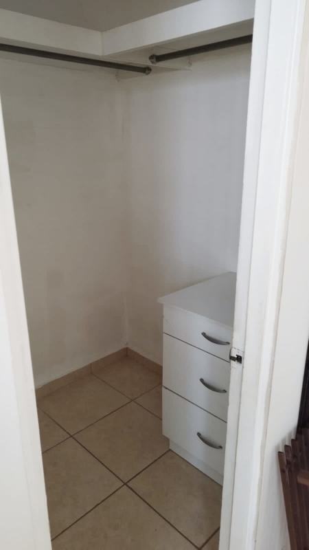 Fenced backyard with covered terrace and BBQ grill in family house Brisas del Golf Panama