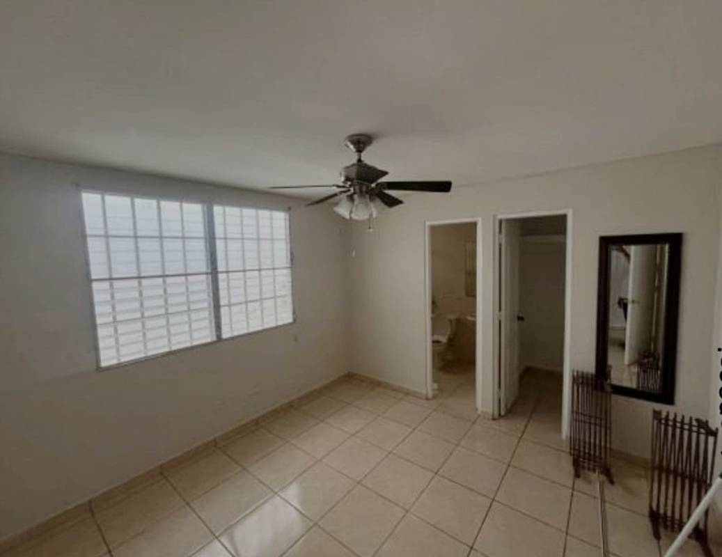 Simple tiled bathroom with shower, pedestal sink and window in family home Brisas del Golf Panama
