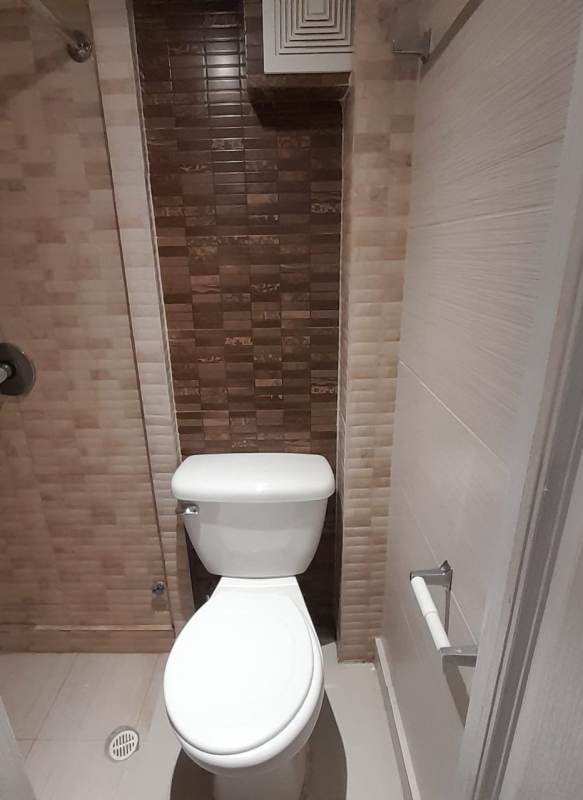 Modern private bathroom with tiled shower, ceramic toilet and beige tiles Casa Rica Banking District Panama