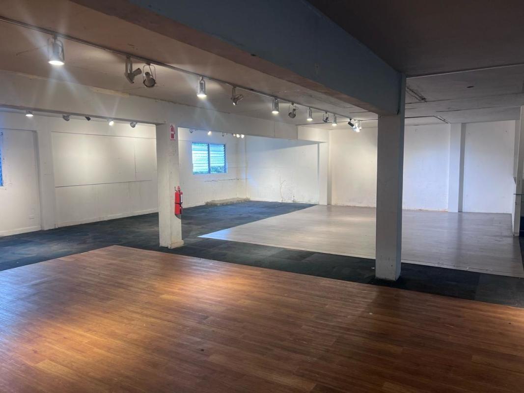 Open commercial interior with track lighting, white walls, windows in Panama City Perejil