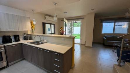 Dining room with glass table and pendant lights Bosques del Pacífico Howard house for rent