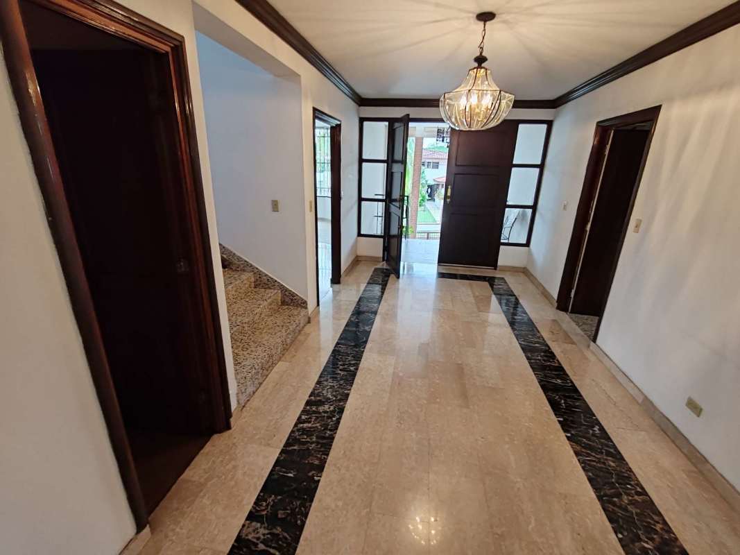 Spacious kitchen with white cabinets, orange countertops, barred windows in Altos del Golf Panama City