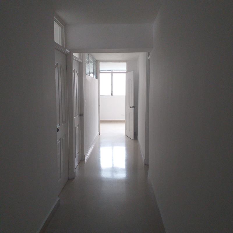 Minimalist hallway with white walls, tile floor, multiple doors in PH Vista Mar Calle 50 Panama
