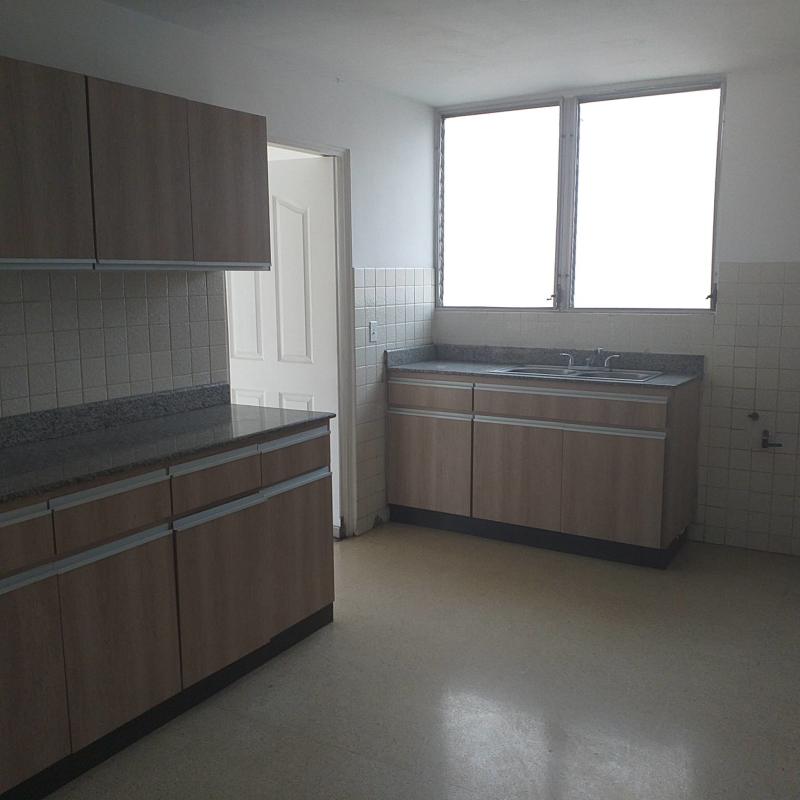 Kitchen with wood cabinets, granite counters, tile backsplash in PH Vista Mar Obarrio Panama