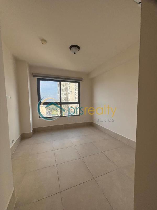 Empty bedroom with large window and porcelain tile floors at PH Ocean House