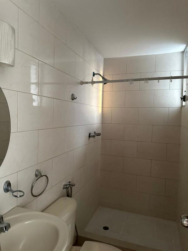 Bathroom with glass louvers tile walls pedestal sink PH Central Park Tocumen Panama