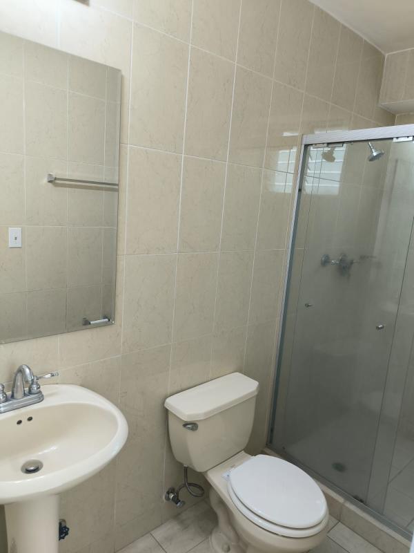 Modern bathroom with tiled shower and pedestal sink in Edison Park Panama apartment