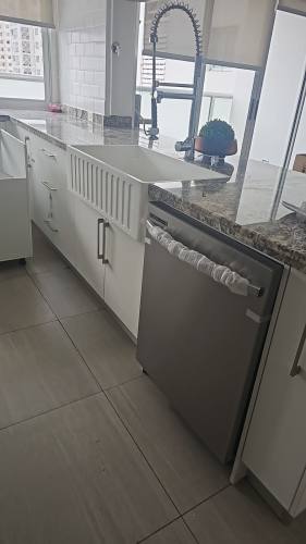 Spacious kitchen with granite island, pendant lighting in Pacific Sea Apartment San Francisco