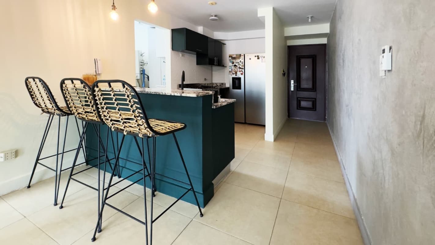 Kitchen with granite breakfast bar, pendant lights, fridge, and woven bar stools Villa Cáceres Panama