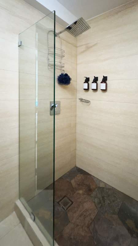Bathroom with rainfall shower, beige tile, and modern sink at Villa Cáceres Betania Panama