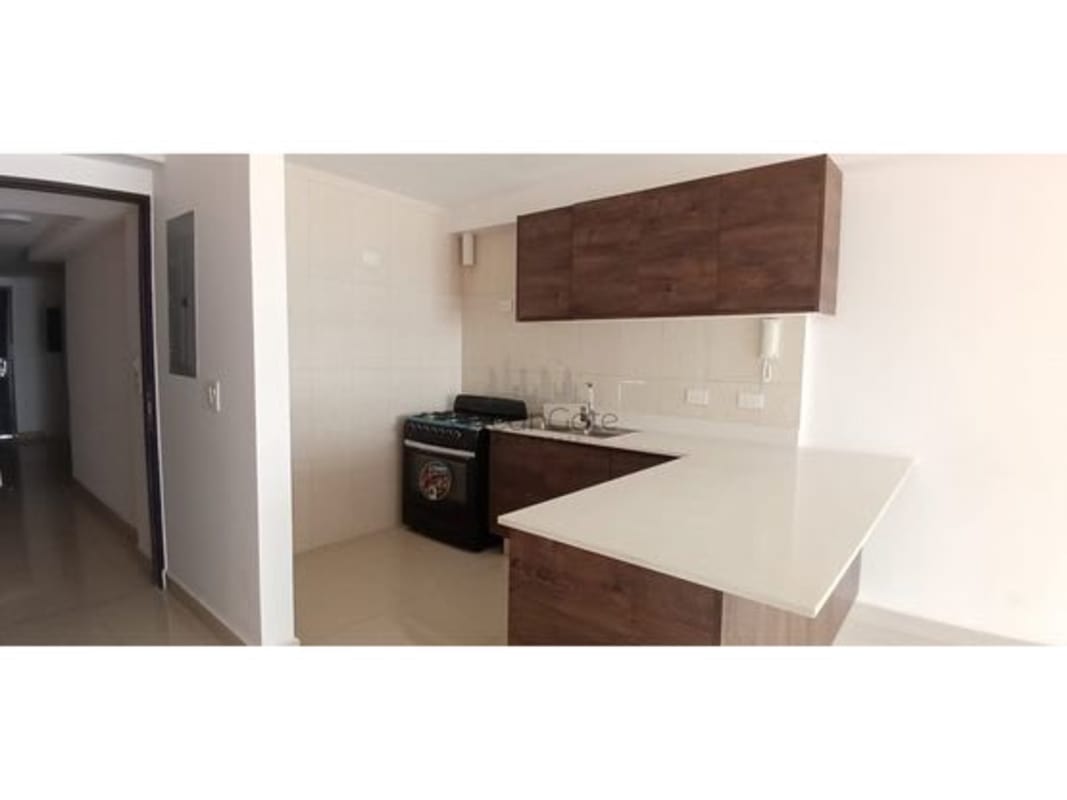 Modern kitchen with gas stove, refrigerator, and wooden cabinets in PH Vichy Village Panama City