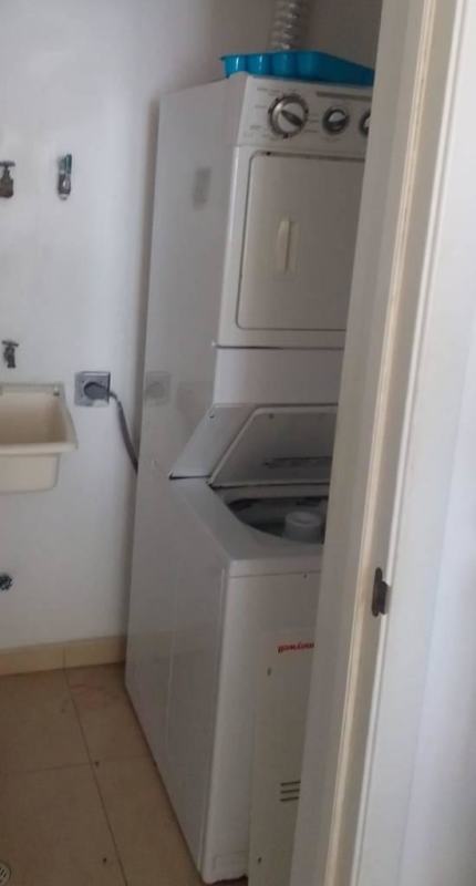 Laundry area with stacked washer dryer and utility sink PH White Tower Marbella Panama