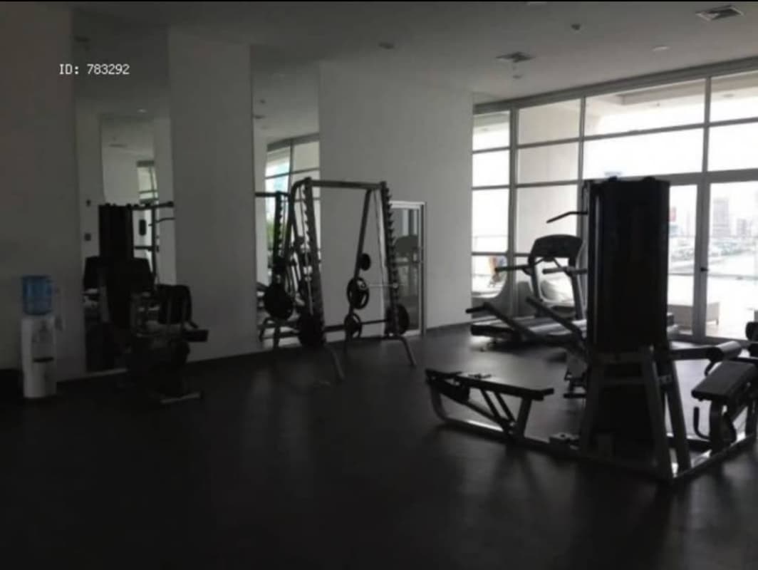 Full gym with treadmills, weights and mirrors overlooking city skyline PH White Tower Panama City