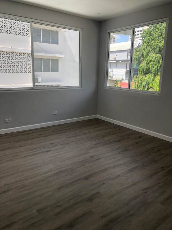 Spacious bedroom, natural light, wood-look floor, gray and white walls in Obarrio Panama rental apartment