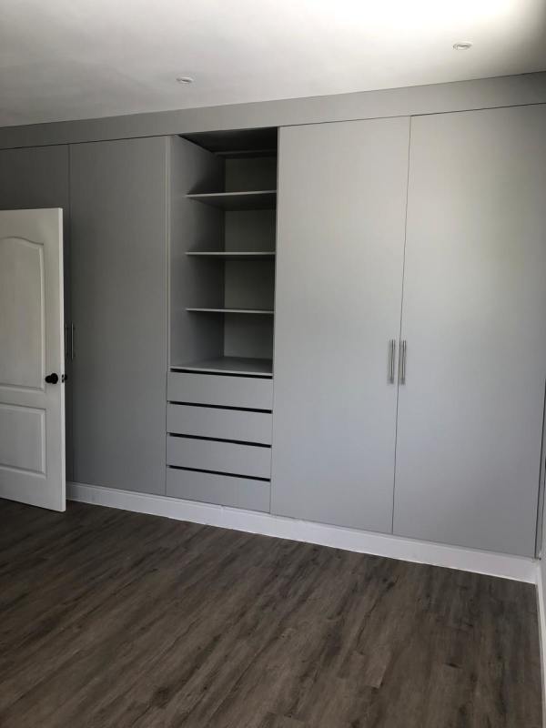 View from bedroom door to bathroom entry, tiled floor, neutral tones, remodeled Panama City rental Obarrio