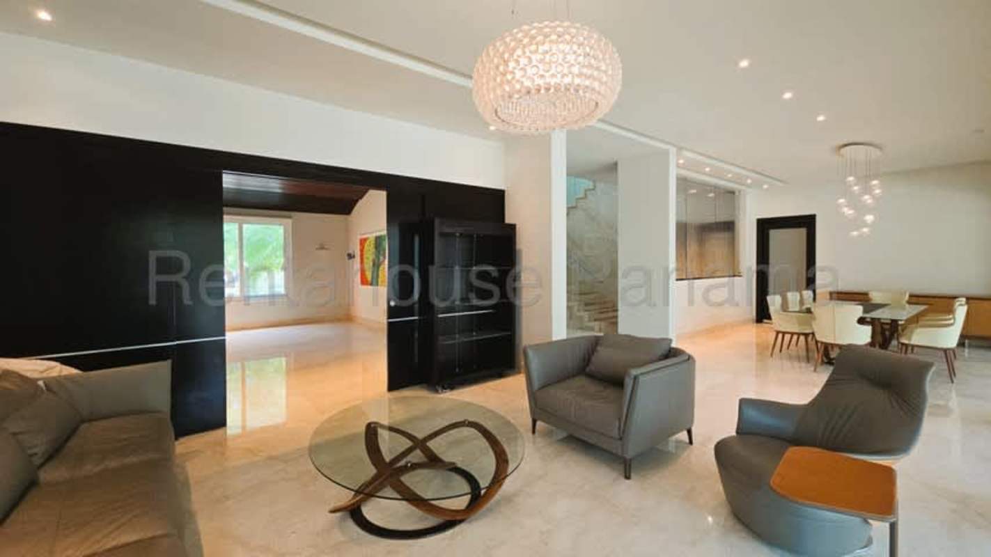 Modern living dining area with marble floors, glass doors and pool view in Costa del Este luxury home
