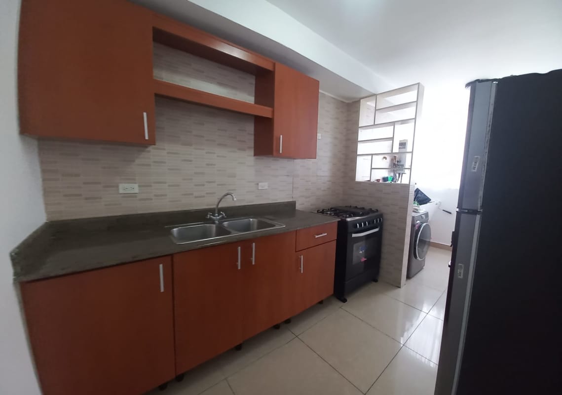 Kitchen with wooden cabinets, double sink, gas stove, fridge and laundry area PH San Francisco Bay Panama